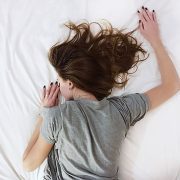 Woman sleeping facedown on a bed.